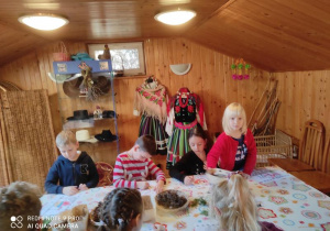 Dzieci kolorują obrazek z Mikołajem.